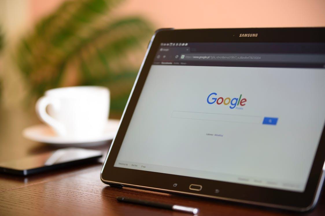 The Google homepage displaying on the screen of a propped up tablet