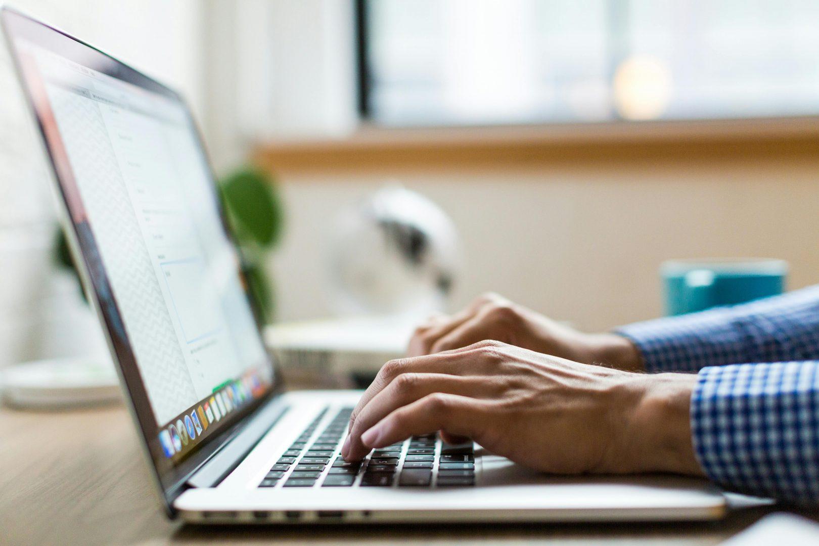 Someone types on a laptop at a marketing agency in Surrey