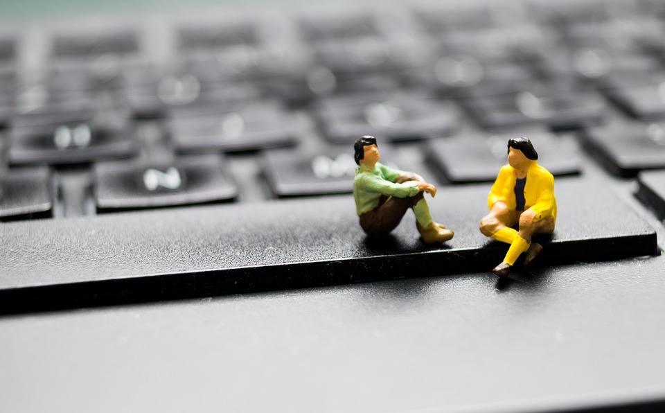 Two minute figures discuss Web Design in Guildford whilst sitting on a keyboard's space bar