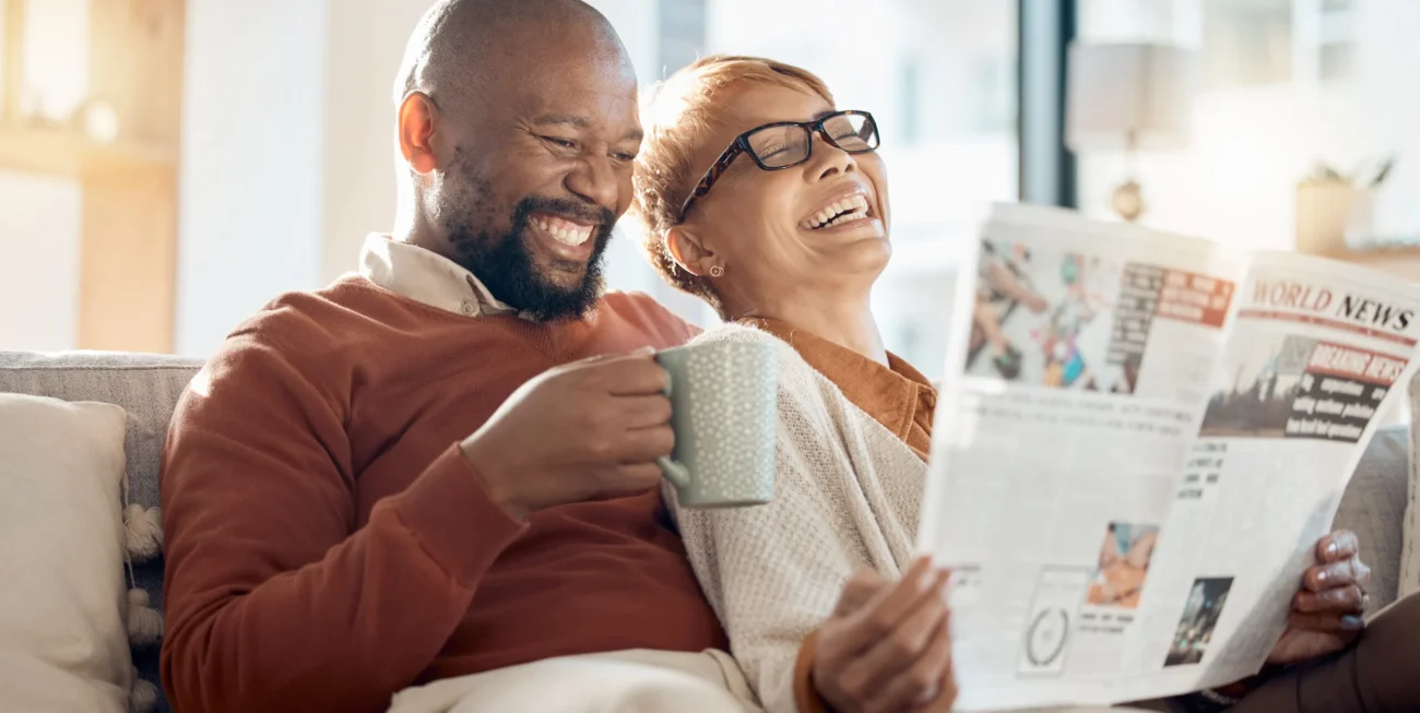 Laughing couple reading a newspaper | Bespoke website