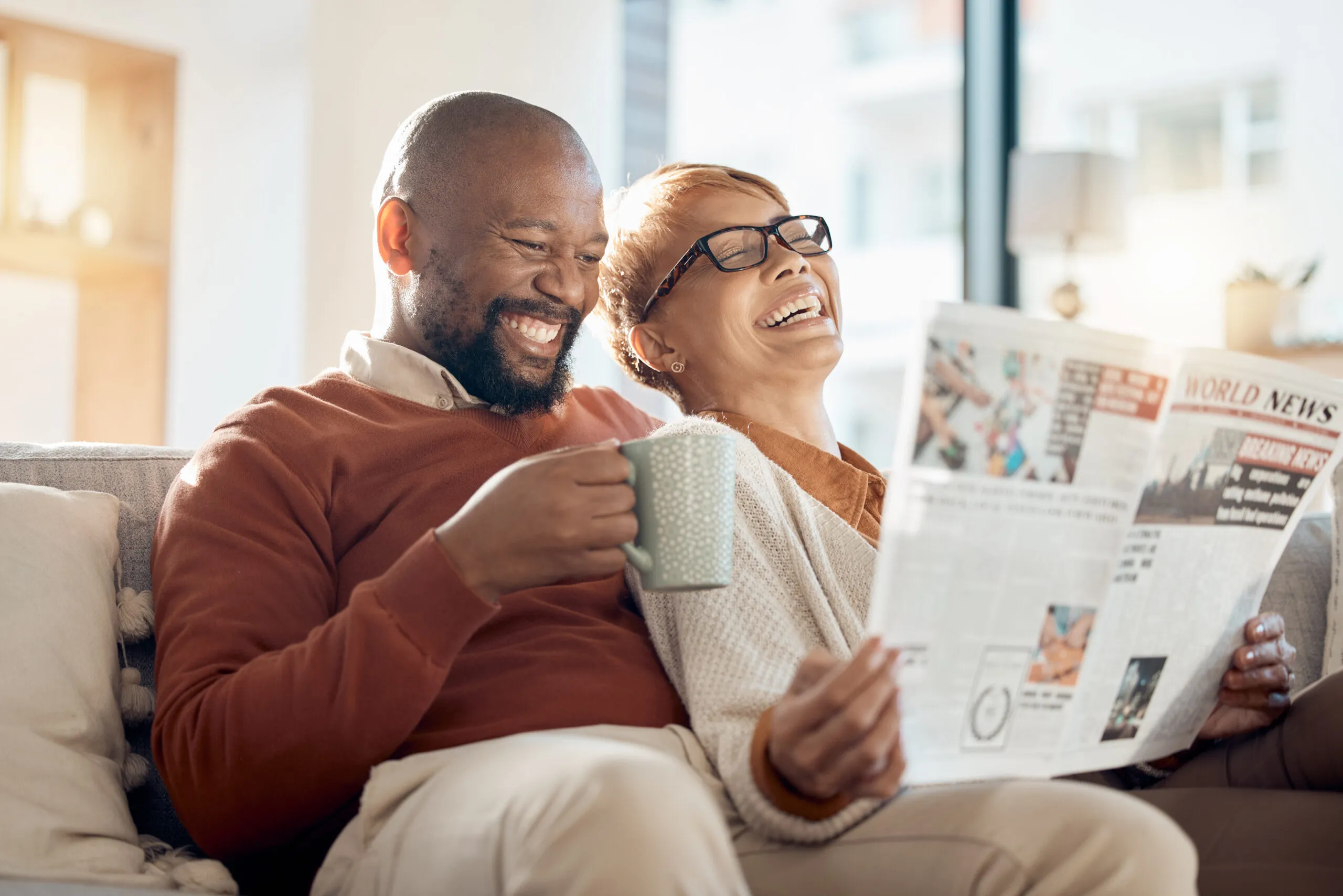 Laughing couple reading a newspaper | Bespoke website