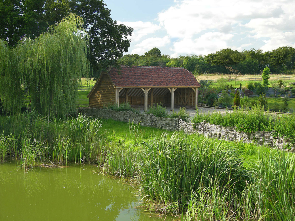 A bespoke oak barn created by The Brookwood Barn Co, nestled in green scenery | Technical SEO