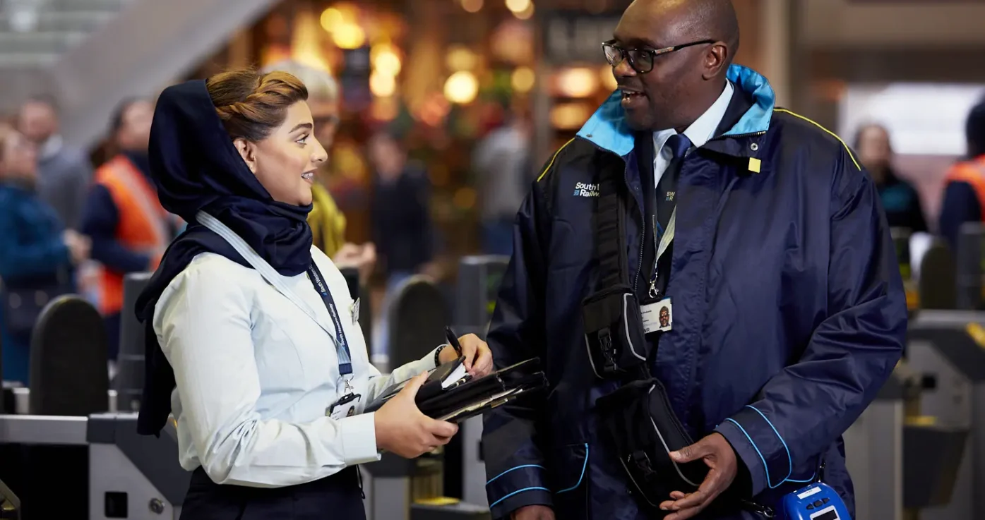 Two South Western Railway staff at work in their JSD-designed uniforms