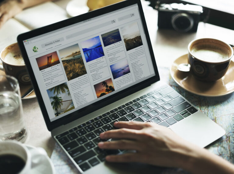 Person using laptop whose business is invisible online, with coffee nearby.