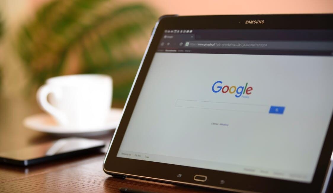 The Google homepage displaying on the screen of a propped up tablet
