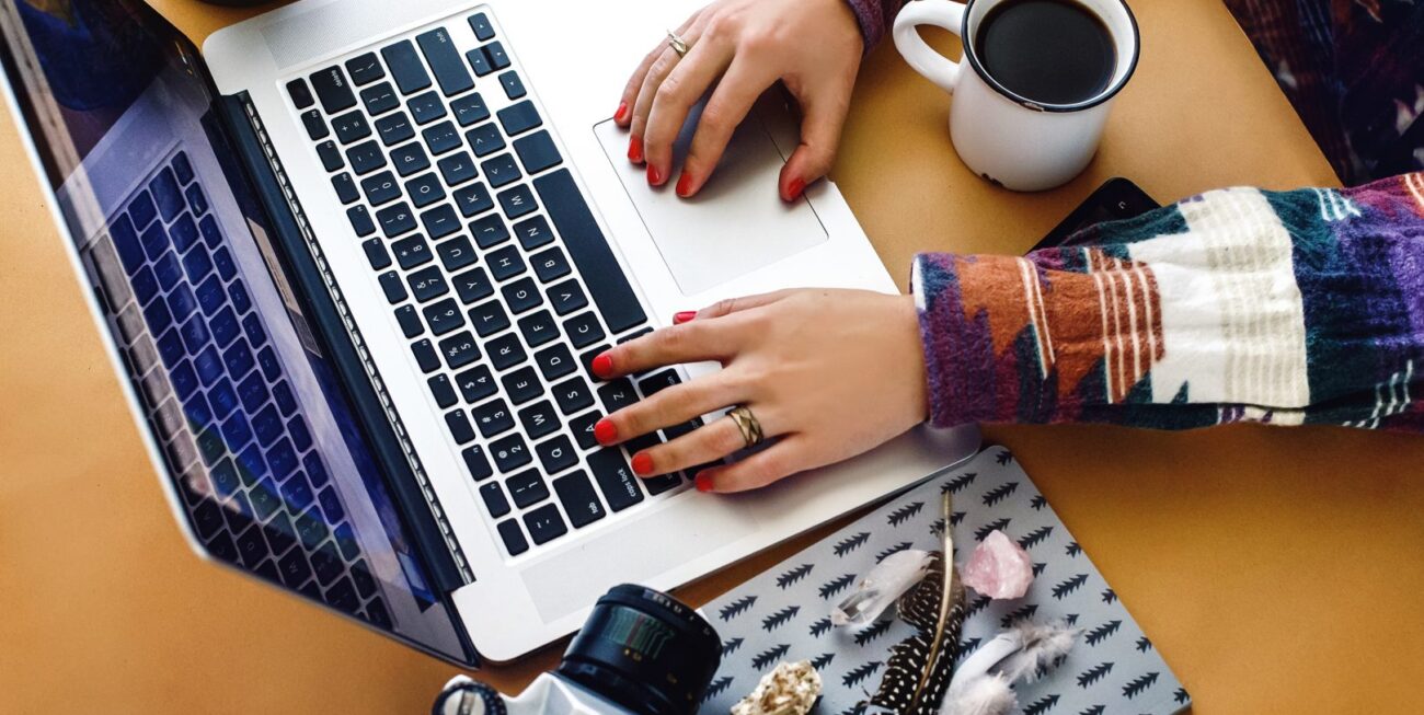 A person typing on a laptop, probably working on advertising in Surrey