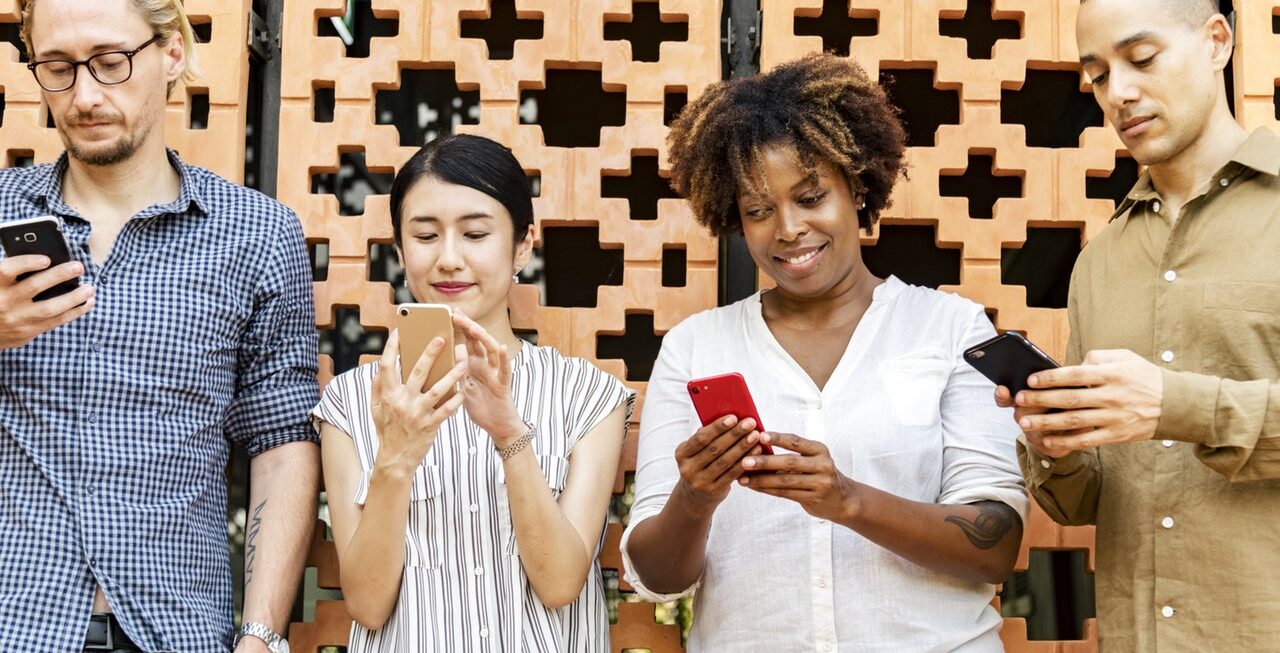People looking at their phones, engaging with content from our social media company in Surrey