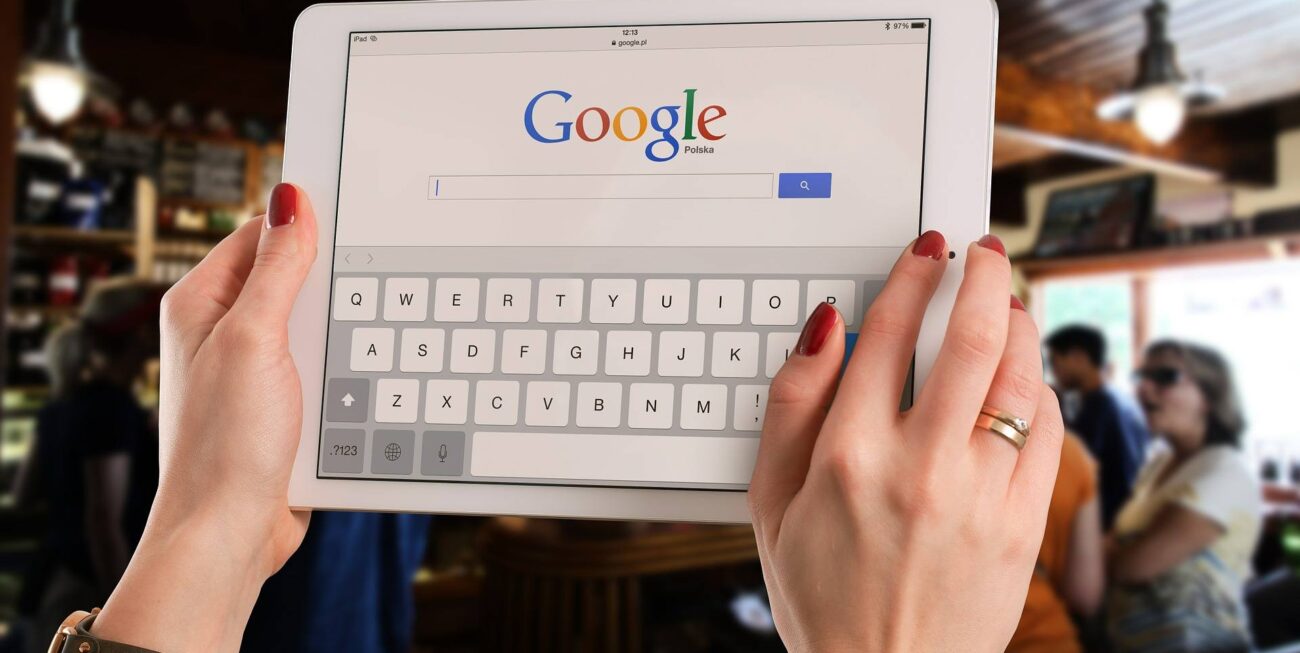 A woman holding up an iPad whilst searching on Google