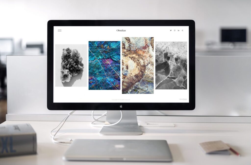 A computer on a desk with 4 photos on the screen