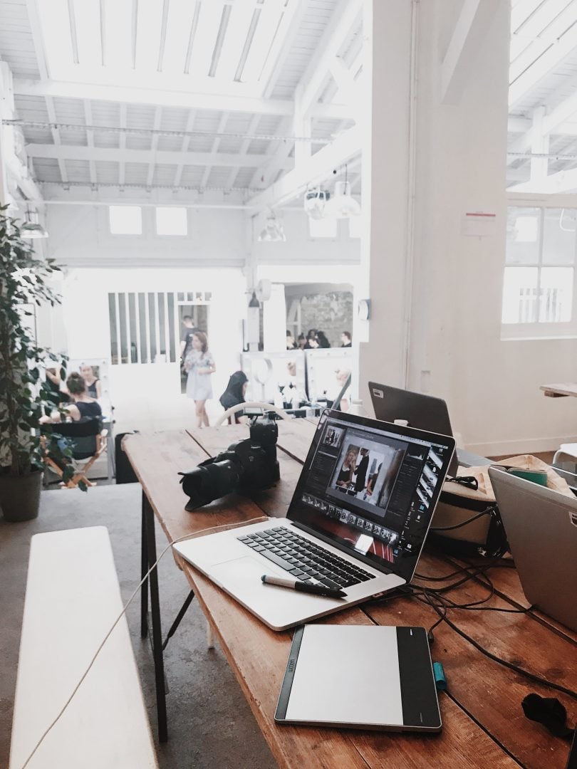 A laptop on top of a desk in an office.