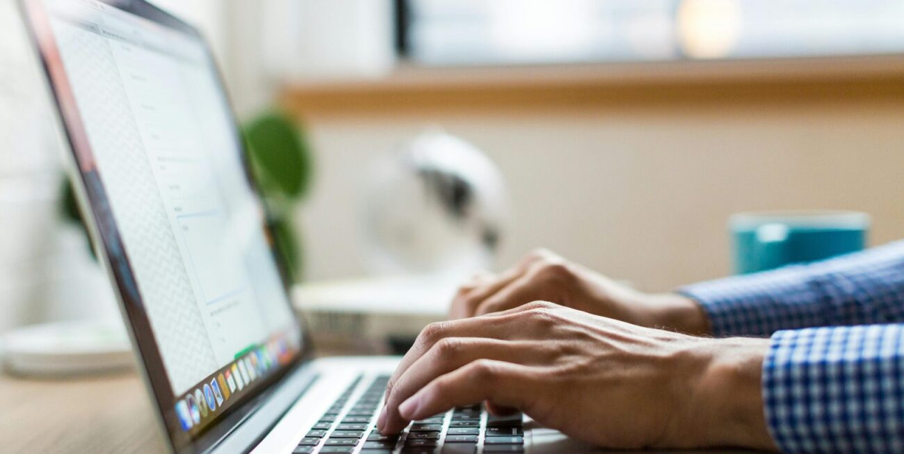 Someone types on a laptop at a marketing agency in Surrey