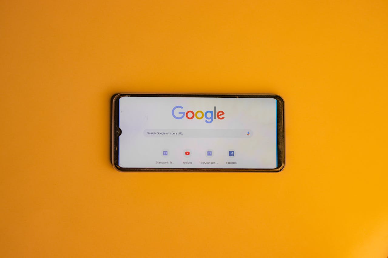 A phone showing Google on a yellow background | Surrey web design