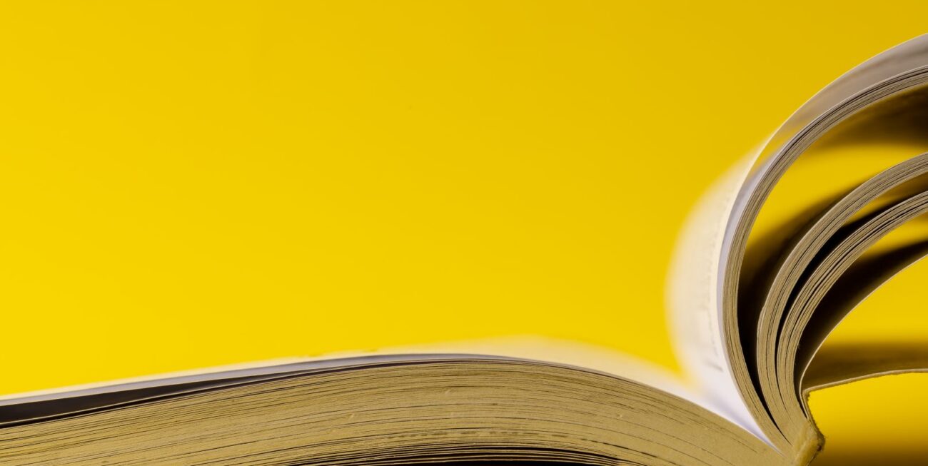 A picture of an open book on a yellow background | Web Design Surrey