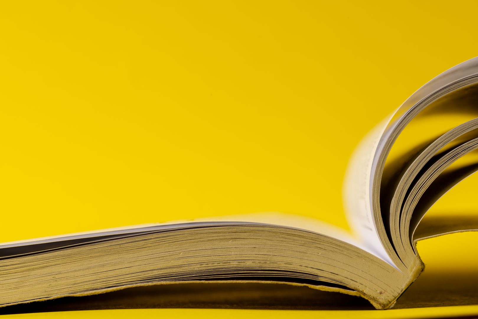A picture of an open book on a yellow background | Web Design Surrey