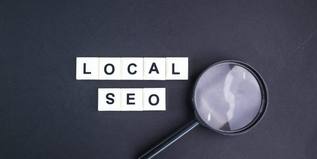 Scrabble tiles spelling out local SEO next to a magnifying glass | Local SEO Surrey