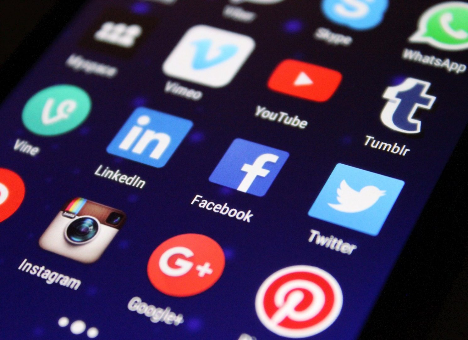 A photo of different social media apps on a phone screen, including Facebook, Instagram and Twitter.
