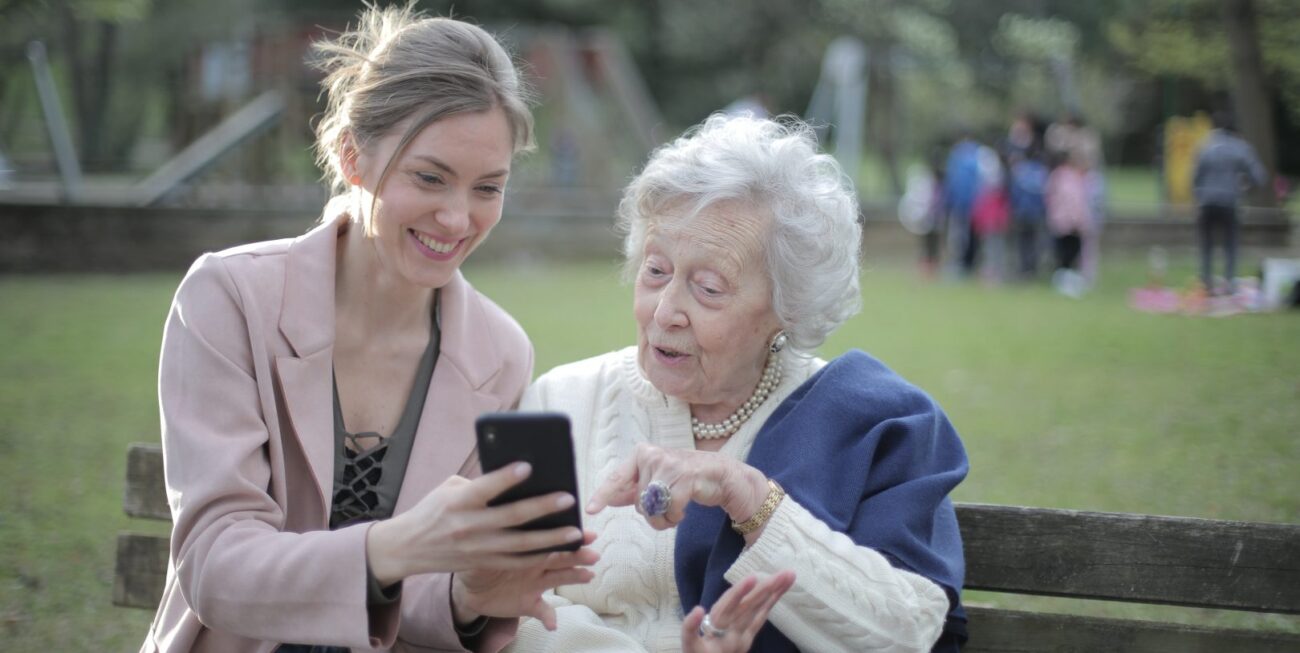A younger woman showing an older woman something on her phone