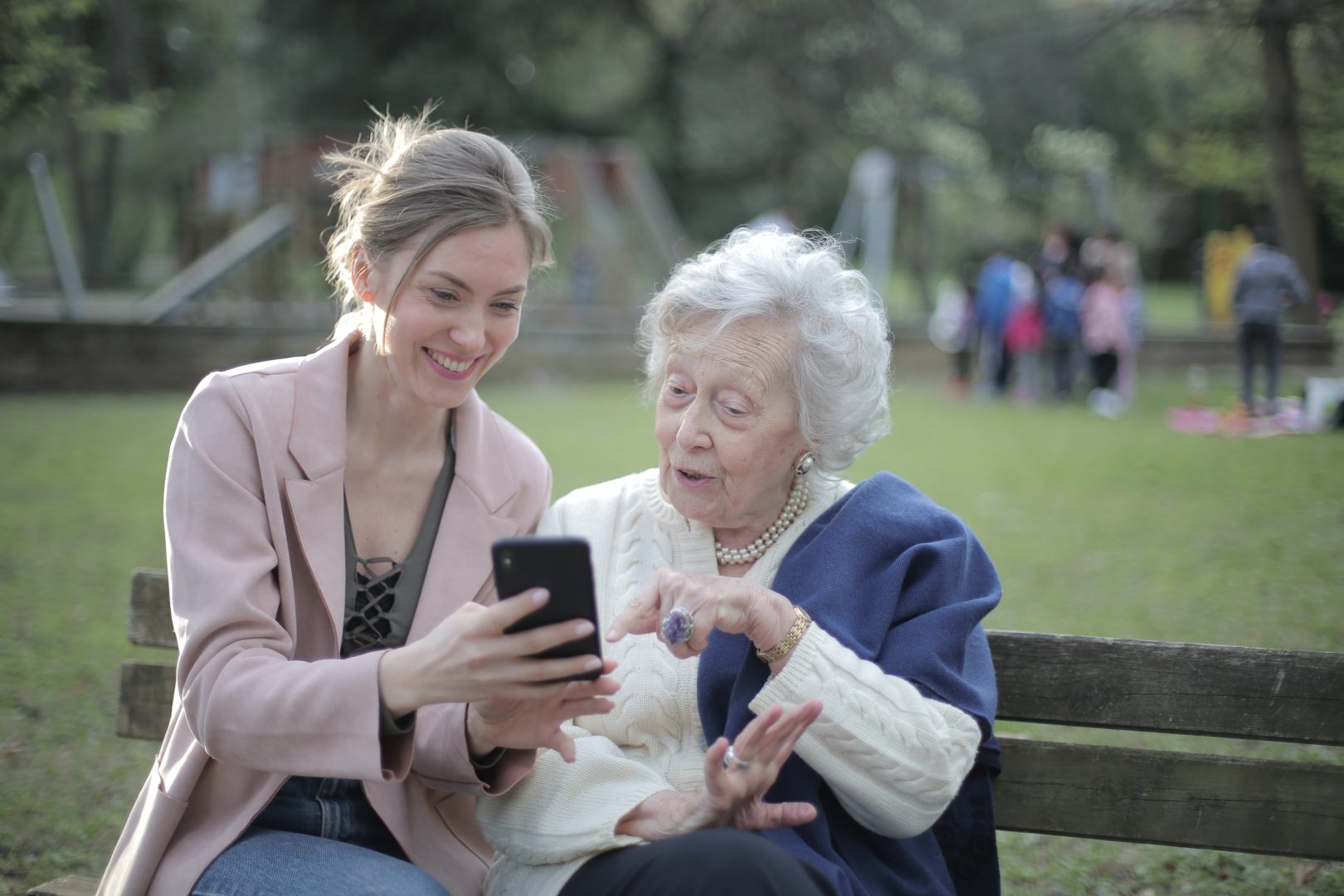 A younger woman showing an older woman something on her phone