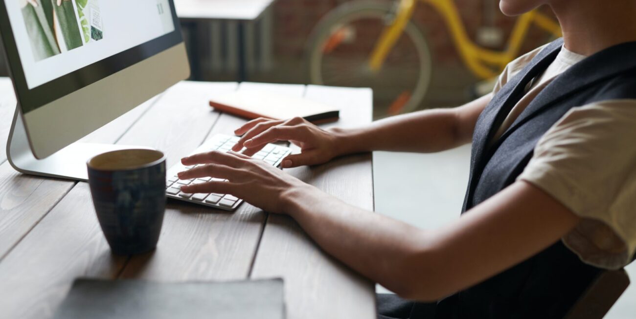 A woman working on her desktop computer in a coffee shop