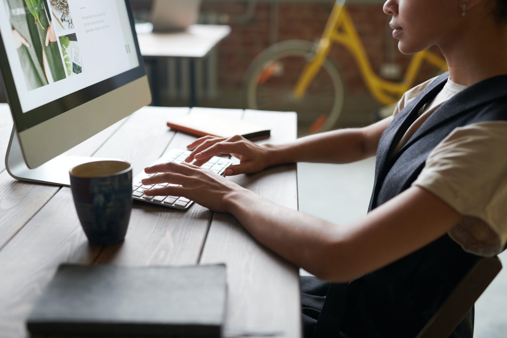 A woman working on her desktop computer in a coffee shop