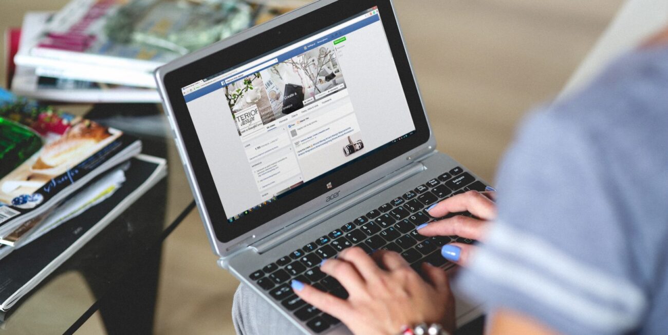 A woman looking at a Facebook business page on a laptop