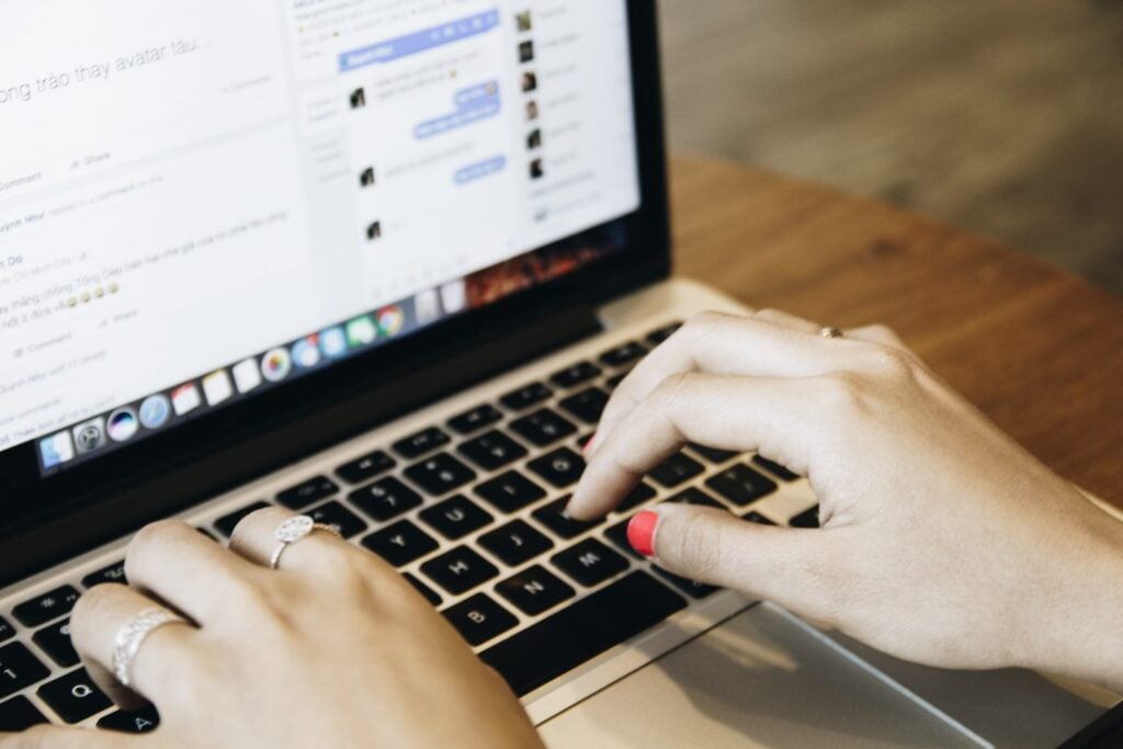 Someone typing in Facebook Messenger on a laptop