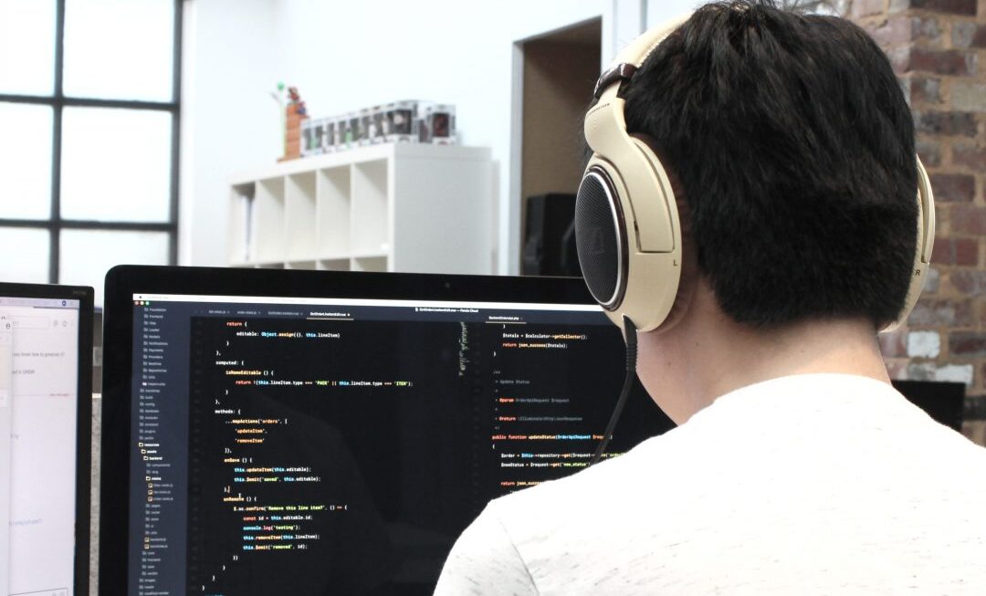 A man designing a website on a computer - as would be carried out by our web design in Surrey team.