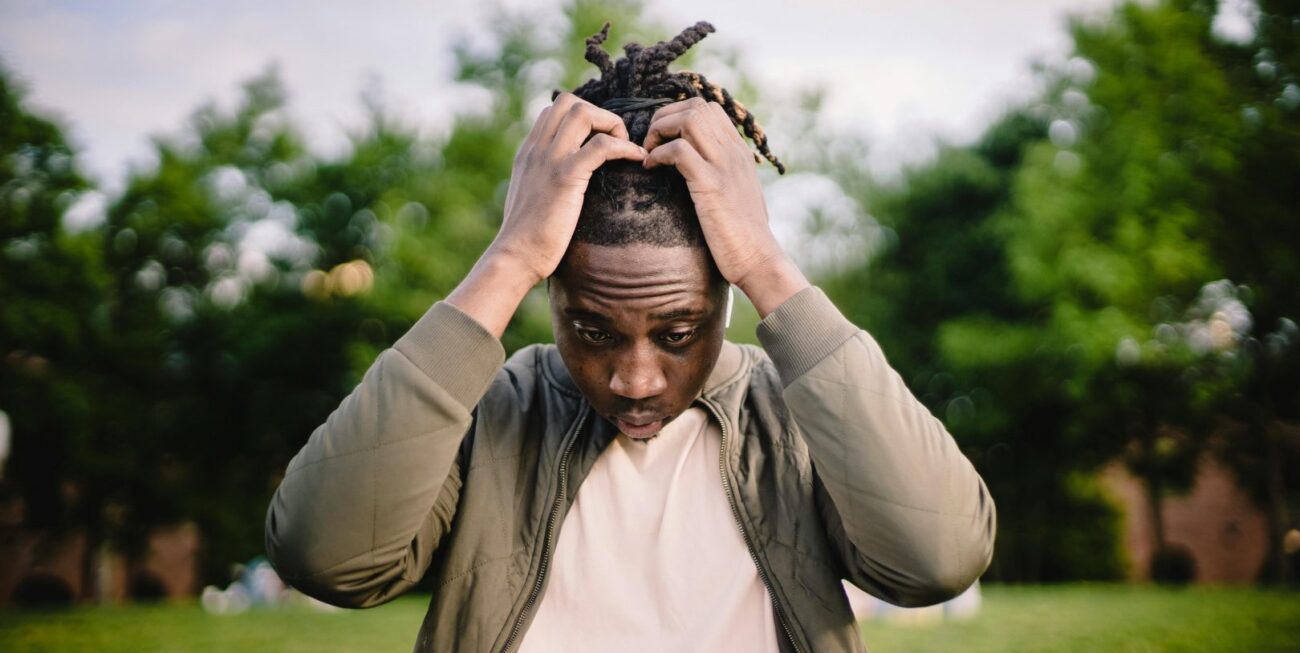 A man holding his head in stress while looking at a laptop showing bad web design in Surrey