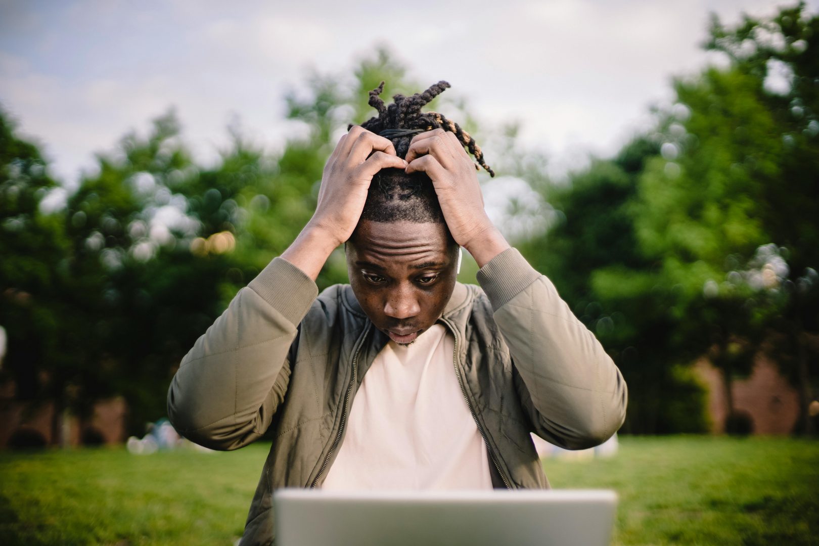 A man holding his head in stress while looking at a laptop showing bad web design in Surrey