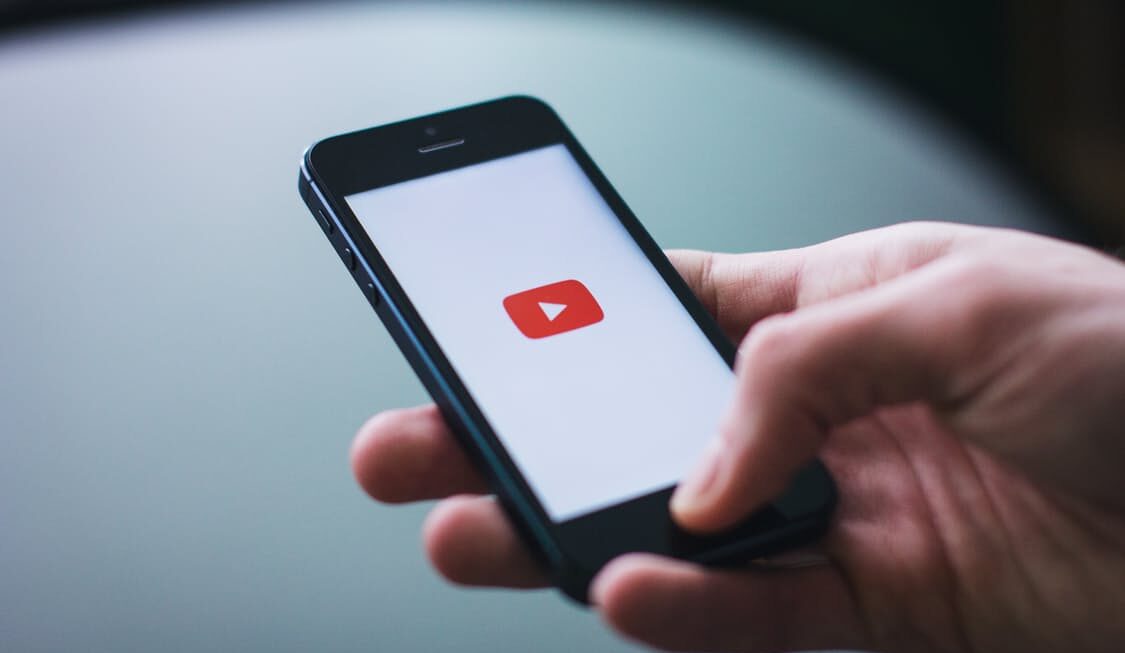 Someone opening the YouTube app on an iPhone Web design surrey | Thunderbolt Digital