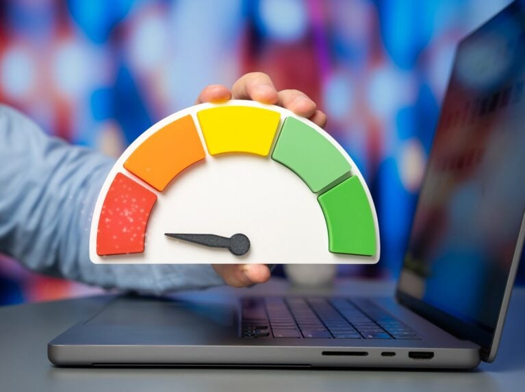 Laptop with a credit score speedometer in front, representing site speed