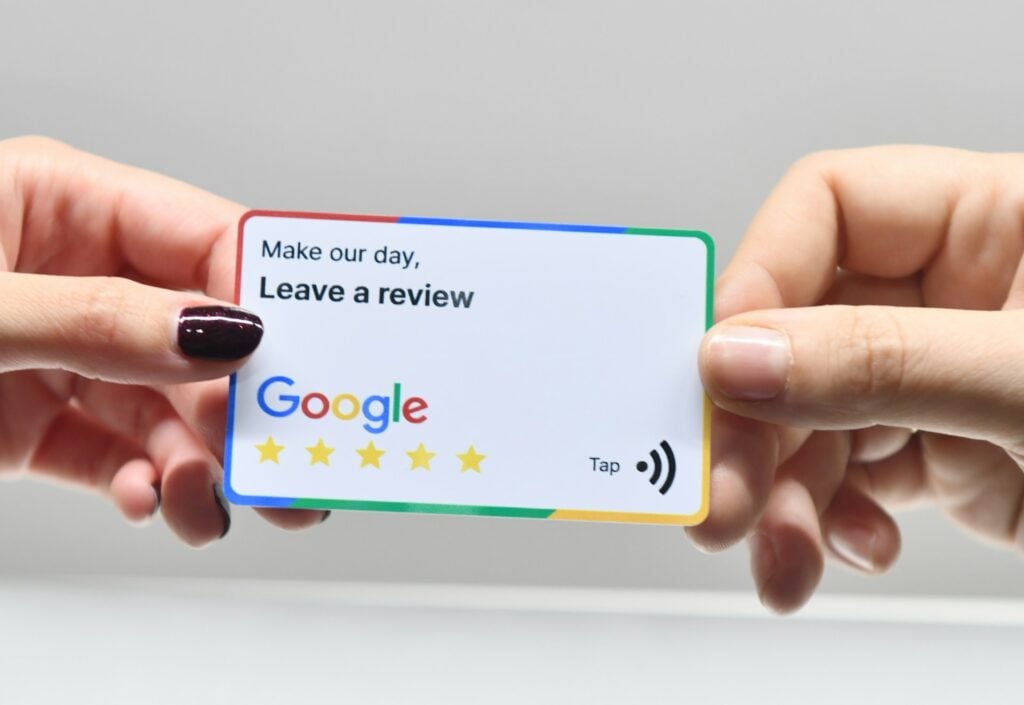 Person handing a Google review card to another person
